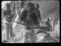Image of Four Inuit. Girl with rifle
